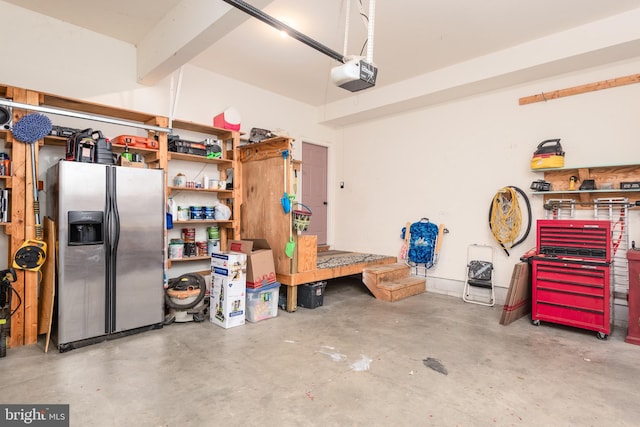 garage with stainless steel fridge with ice dispenser and a garage door opener