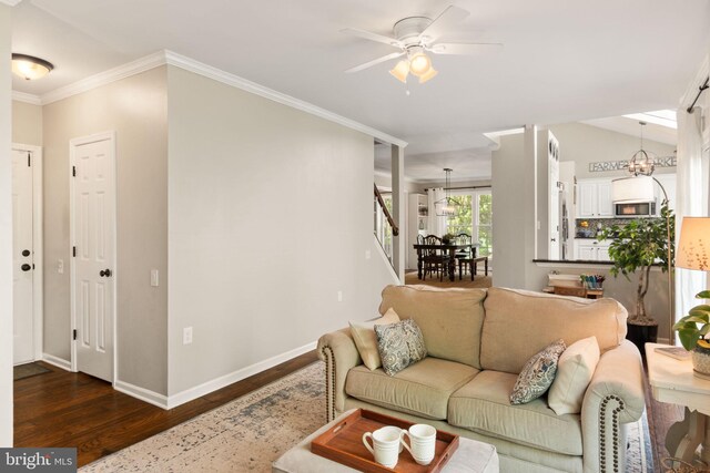 336 Deerpath Ave SW, Leesburg, VA 20175 - living area with dark wood-style floors, ceiling fan, a chandelier, ornamental molding, and baseboards