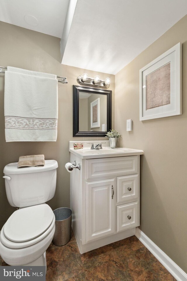 336 Deerpath Ave SW, Leesburg, VA 20175 - half bathroom with baseboards, vanity, toilet, and stone finish floors