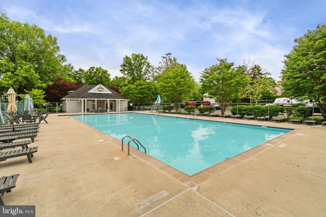 336 Deerpath Ave SW, Leesburg, VA 20175 - community pool featuring a patio area and view of wooded area