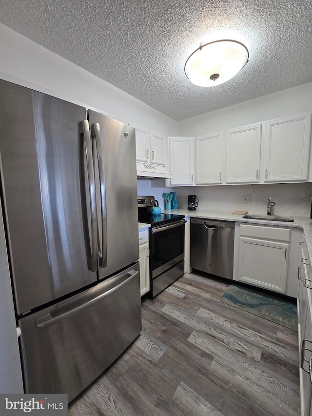 13100 Coastal Hwy Unit 1110, Ocean City, MD 21842 - kitchen with appliances with stainless steel finishes, a sink, a textured ceiling, under cabinet range hood, and white cabinets