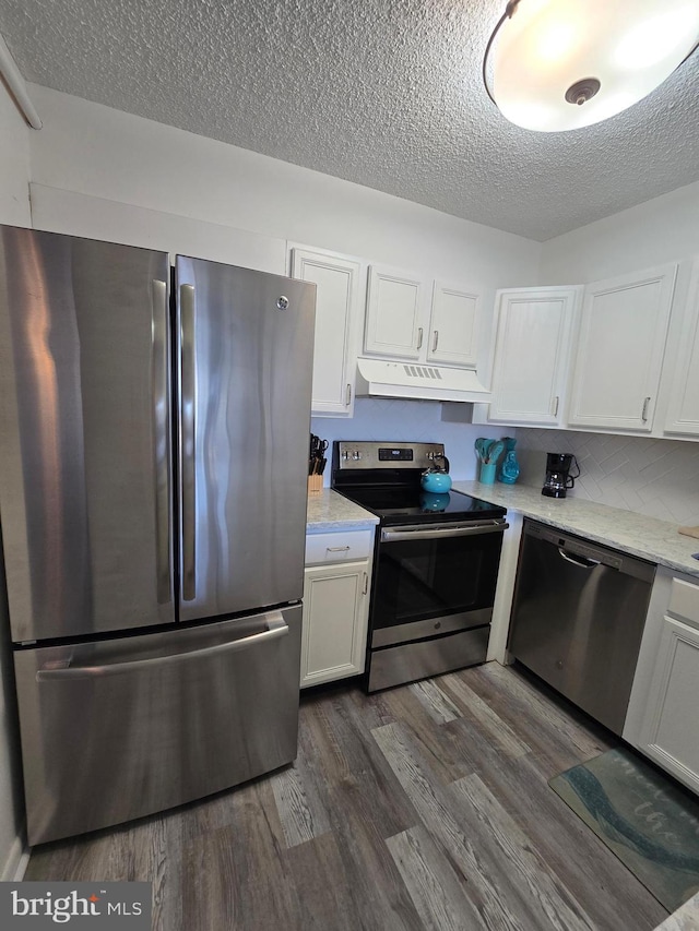 13100 Coastal Hwy Unit 1110, Ocean City, MD 21842 - kitchen with stainless steel appliances, under cabinet range hood, a textured ceiling, white cabinets, and dark wood-type flooring