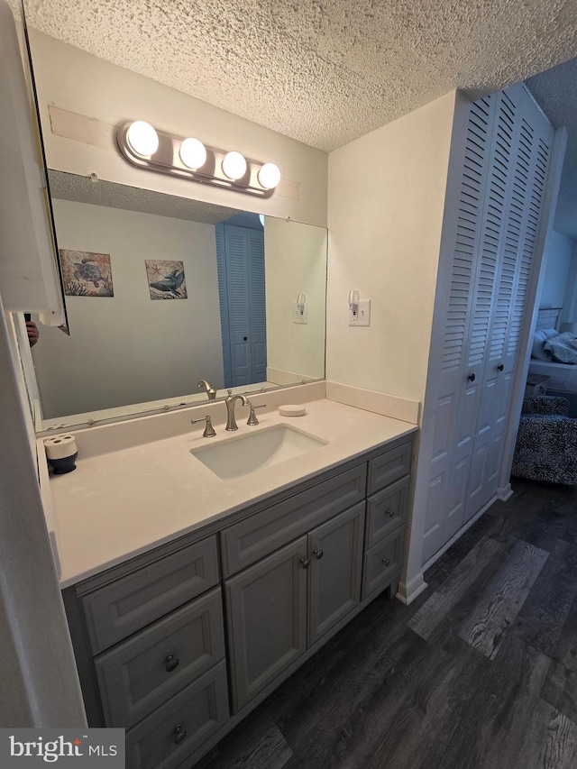 13100 Coastal Hwy Unit 1110, Ocean City, MD 21842 - bathroom featuring wood finished floors, vanity, a textured ceiling, and a closet