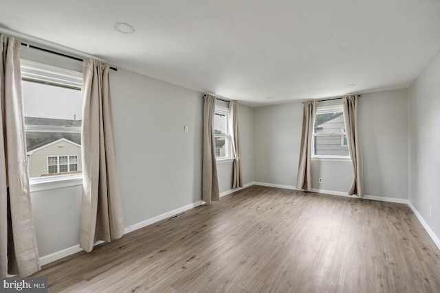 empty room featuring wood finished floors and baseboards