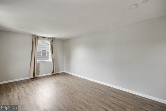 spare room with wood finished floors and baseboards