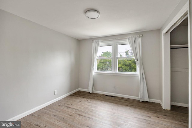 unfurnished bedroom featuring light wood-type flooring and baseboards