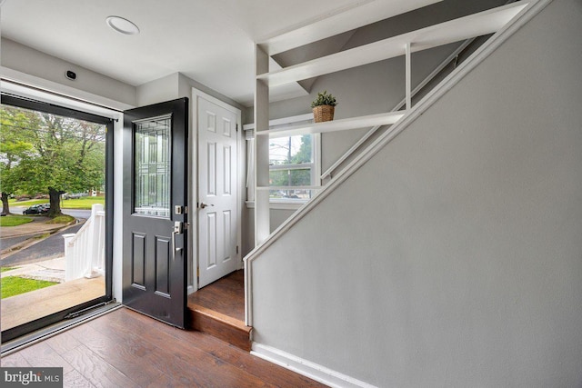 foyer entrance with wood-type flooring and baseboards