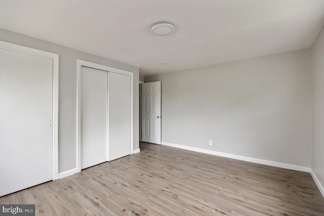 unfurnished bedroom with wood finished floors and baseboards