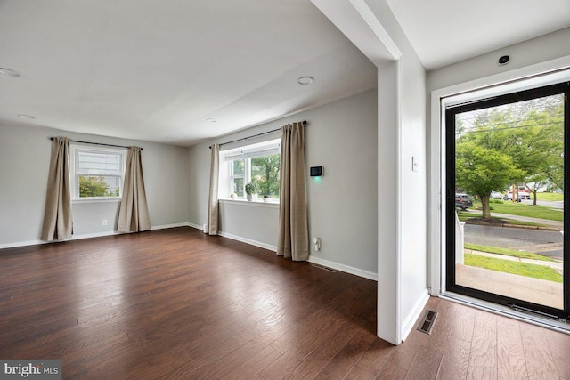 spare room with dark wood-style floors and baseboards