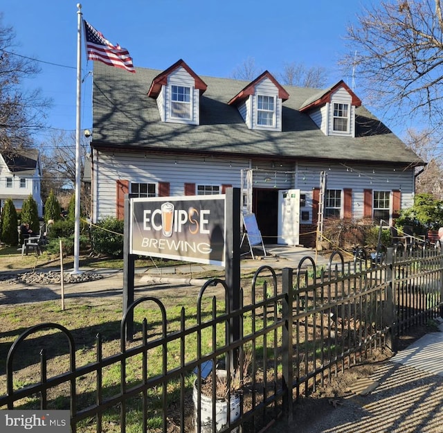 new england style home featuring fence