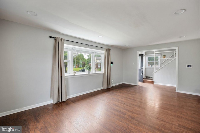unfurnished room featuring plenty of natural light, wood finished floors, baseboards, and recessed lighting