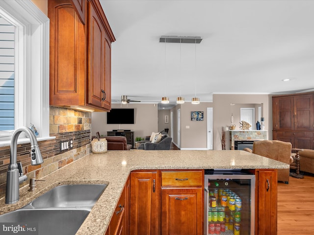 2039 Choptank Ave, Pasadena, MD 21122 - kitchen with a fireplace, wine cooler, a sink, open floor plan, and crown molding