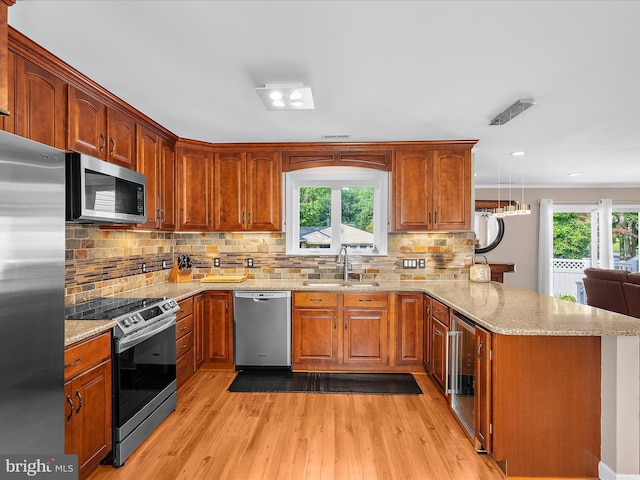 2039 Choptank Ave, Pasadena, MD 21122 - kitchen with appliances with stainless steel finishes, a sink, a peninsula, light wood-style floors, and light stone countertops