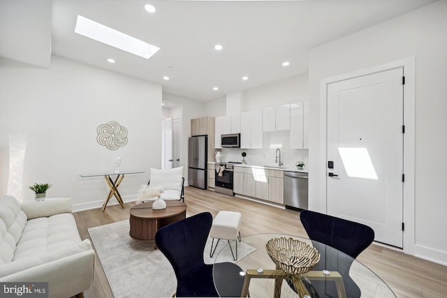 705 Quincy St NE Unit 5D, Washington, DC 20017 - living room with a skylight, light wood finished floors, recessed lighting, and baseboards