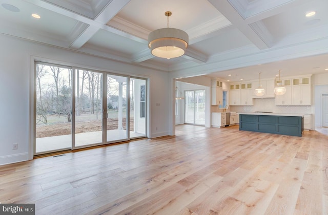 unfurnished living room featuring coffered ceiling, light wood finished floors, beamed ceiling, baseboards, and a sink