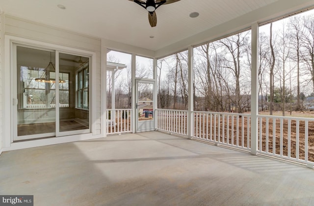unfurnished sunroom featuring a ceiling fan