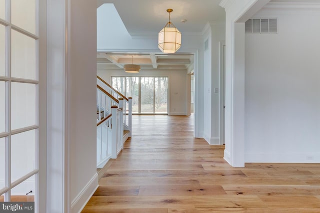 foyer entrance with coffered ceiling, crown molding, stairs, light wood finished floors, and beam ceiling