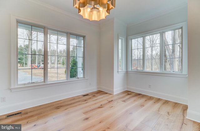 empty room with baseboards, a chandelier, wood finished floors, and ornamental molding