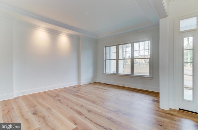 empty room with light wood-style flooring, crown molding, and baseboards