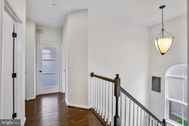 hallway featuring an upstairs landing, dark wood finished floors, and baseboards