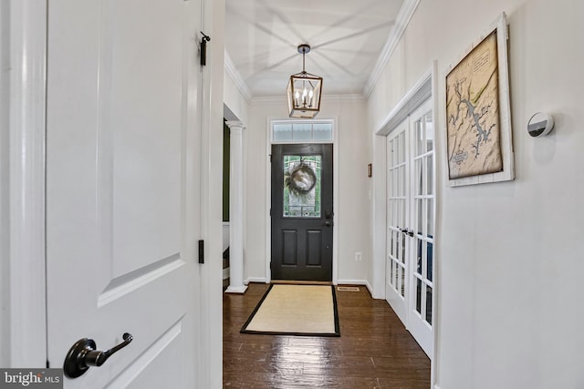 foyer with ornamental molding, dark wood-style flooring, and a chandelier