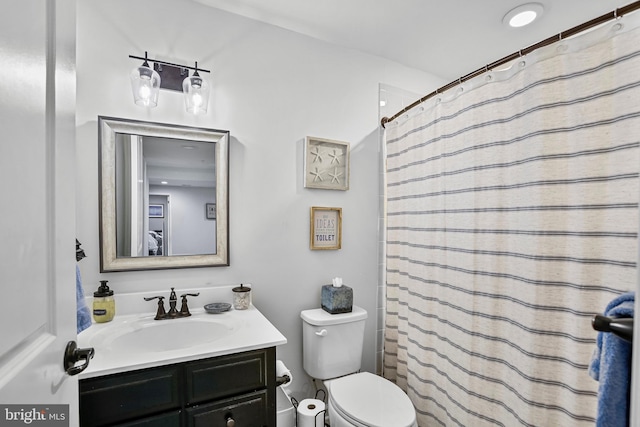 bathroom featuring vanity, toilet, and curtained shower