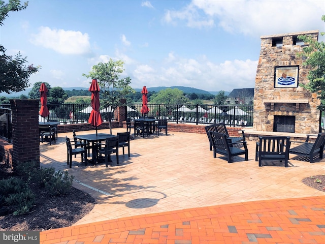 view of patio / terrace featuring an outdoor stone fireplace and outdoor dining area
