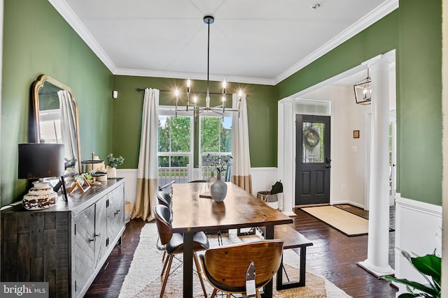 dining room with a chandelier, healthy amount of natural light, crown molding, a wainscoted wall, and dark wood-type flooring