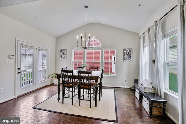 dining room featuring vaulted ceiling, healthy amount of natural light, a chandelier, and dark wood finished floors