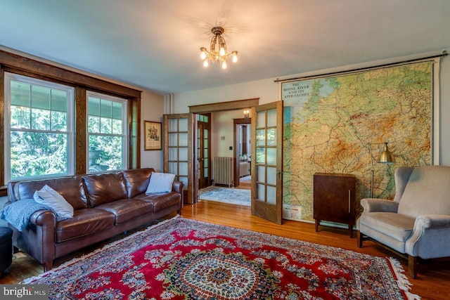 466 E Main St, Leola, PA 17540 - living area featuring a chandelier, french doors, wood finished floors, and radiator heating unit