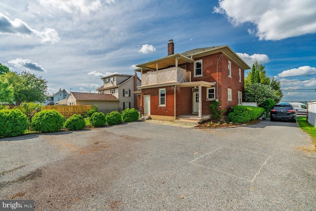 466 E Main St, Leola, PA 17540 - view of front of home with a chimney, brick siding, fence, a balcony, and driveway