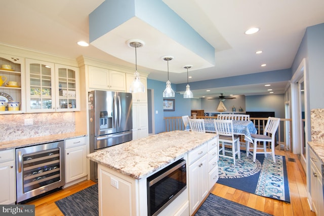 4906 Timbermarsh Ln, Woolford, MD 21677 - kitchen with beverage cooler, stainless steel appliances, light wood-style flooring, a ceiling fan, and decorative backsplash