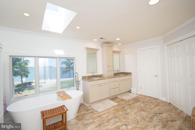 4906 Timbermarsh Ln, Woolford, MD 21677 - bathroom featuring a skylight, crown molding, double vanity, a freestanding tub, and recessed lighting