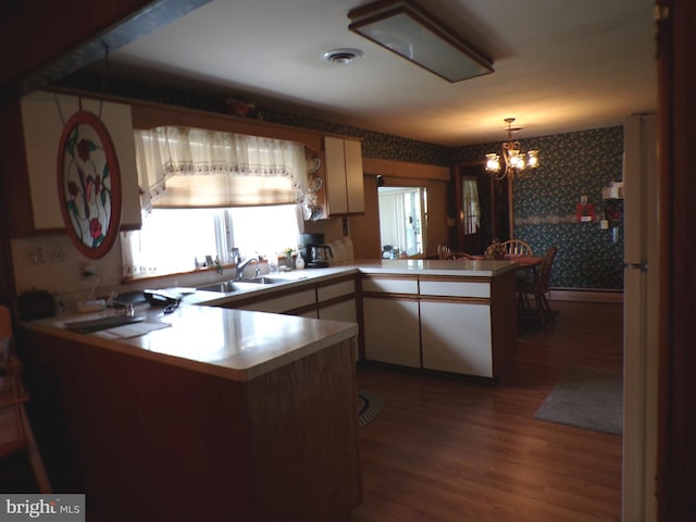 2713 Rowe Rd, New Windsor, MD 21776 - kitchen featuring a peninsula, wallpapered walls, wood finished floors, a chandelier, and a sink