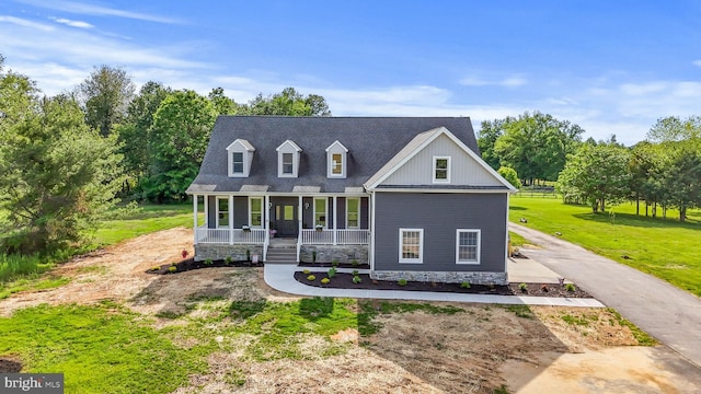 view of front of property featuring a porch, a front lawn, and driveway