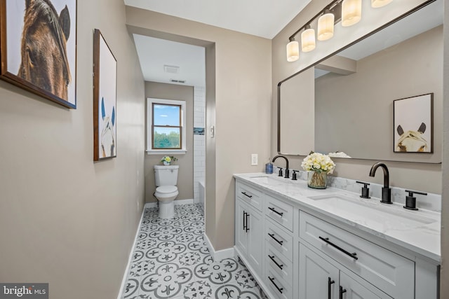 full bathroom with baseboards, toilet, and double vanity