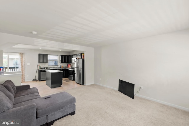 living room with baseboards and light carpet