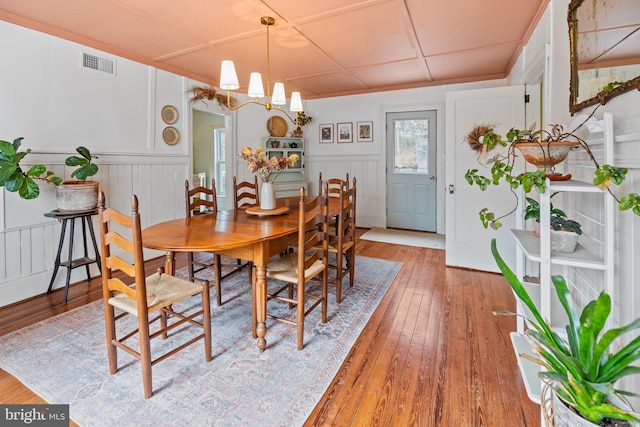 3947 Hebron Valley Rd, Madison, VA 22727 - dining area featuring light wood-style flooring, a chandelier, a decorative wall, and wainscoting