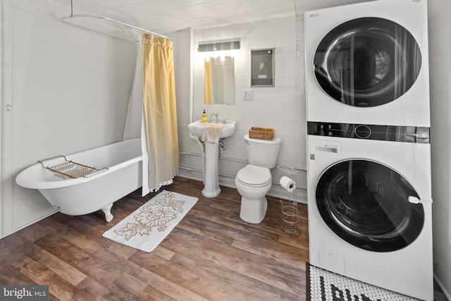 3947 Hebron Valley Rd, Madison, VA 22727 - full bath with stacked washer / drying machine, a freestanding tub, wood finished floors, and toilet