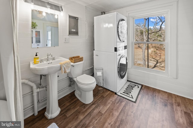 3947 Hebron Valley Rd, Madison, VA 22727 - bathroom featuring stacked washing machine and dryer, toilet, wood finished floors, and a sink