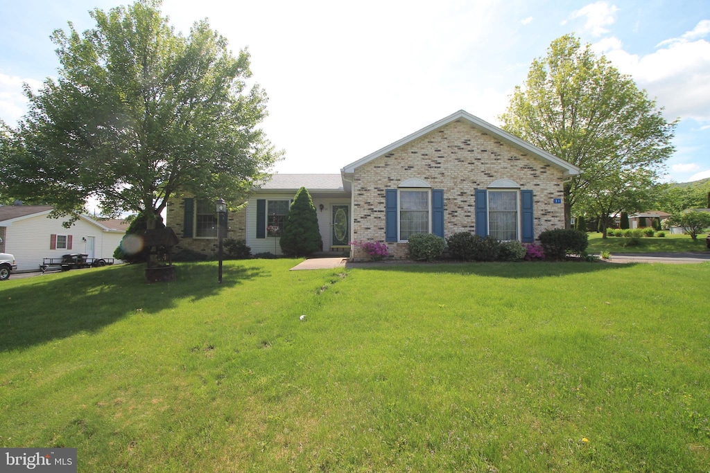 single story home featuring brick siding and a front lawn