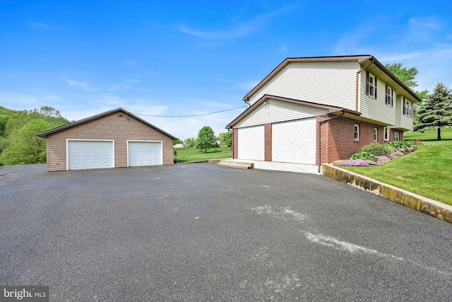 191 Meadow Dr, Mohrsville, PA 19541 - view of side of property with a detached garage, brick siding, an outdoor structure, and a yard