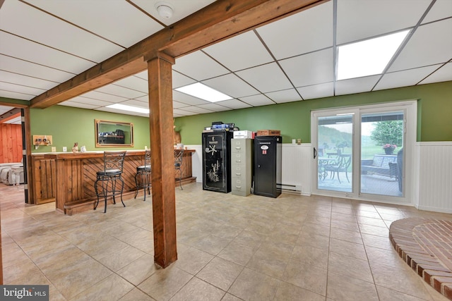 191 Meadow Dr, Mohrsville, PA 19541 - basement featuring bar, a wainscoted wall, baseboard heating, a paneled ceiling, and tile patterned floors