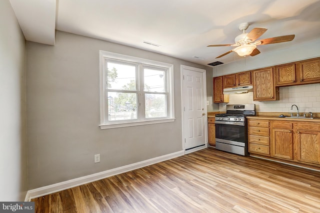 1334 Dalton Rd, Baltimore, MD 21234 - kitchen with stainless steel range with gas stovetop, a sink, baseboards, and light wood-style flooring
