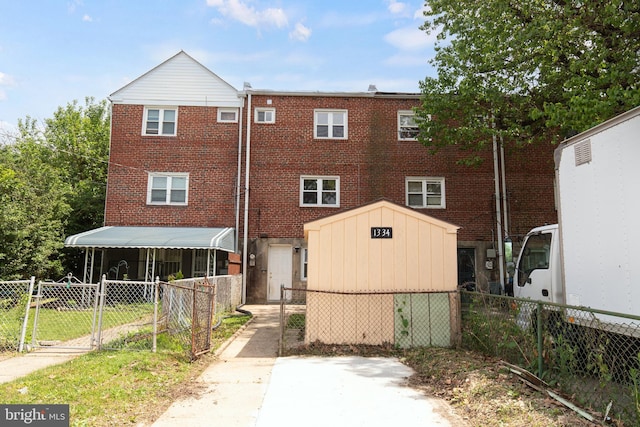 1334 Dalton Rd, Baltimore, MD 21234 - back of house featuring a storage unit, brick siding, a gate, and an outbuilding
