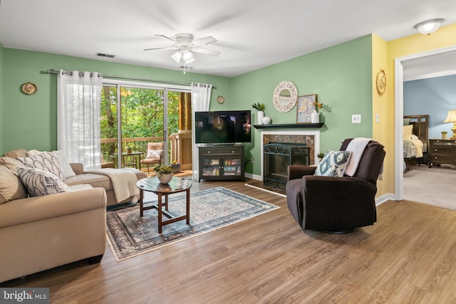603 Admiral Dr Unit 204, Annapolis, MD 21401 - living room featuring ceiling fan, a stone fireplace, wood finished floors, and baseboards