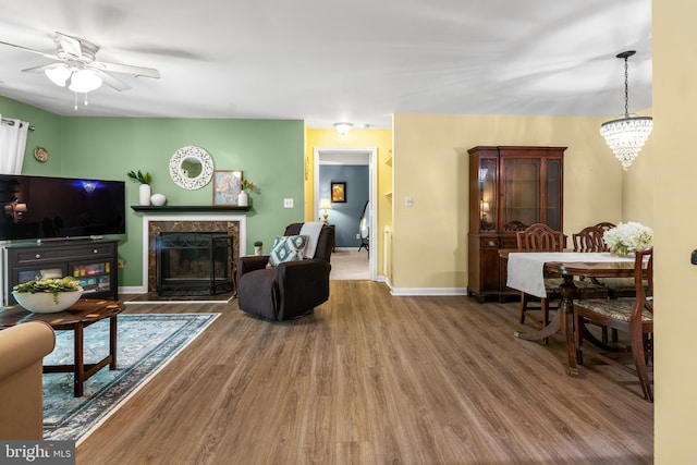 603 Admiral Dr Unit 204, Annapolis, MD 21401 - living room featuring wood finished floors, a ceiling fan, a premium fireplace, baseboards, and a chandelier