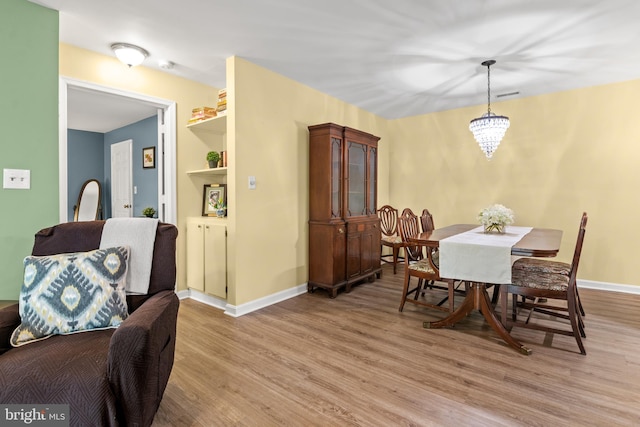 603 Admiral Dr Unit 204, Annapolis, MD 21401 - dining room featuring light wood finished floors, baseboards, and a chandelier