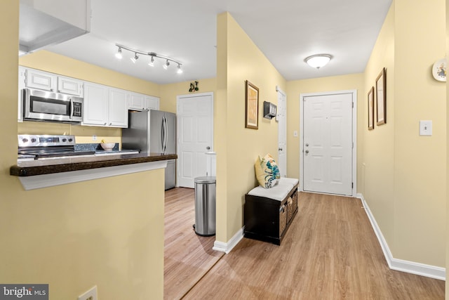 603 Admiral Dr Unit 204, Annapolis, MD 21401 - kitchen with appliances with stainless steel finishes, light wood-type flooring, dark countertops, white cabinets, and baseboards