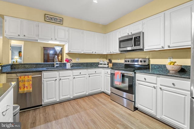 603 Admiral Dr Unit 204, Annapolis, MD 21401 - kitchen featuring appliances with stainless steel finishes, a sink, white cabinetry, light wood-style floors, and dark stone counters